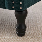 Poltrona moderna imbottita con borchie e gambe in legno