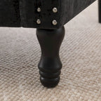 Poltrona moderna imbottita con borchie e gambe in legno